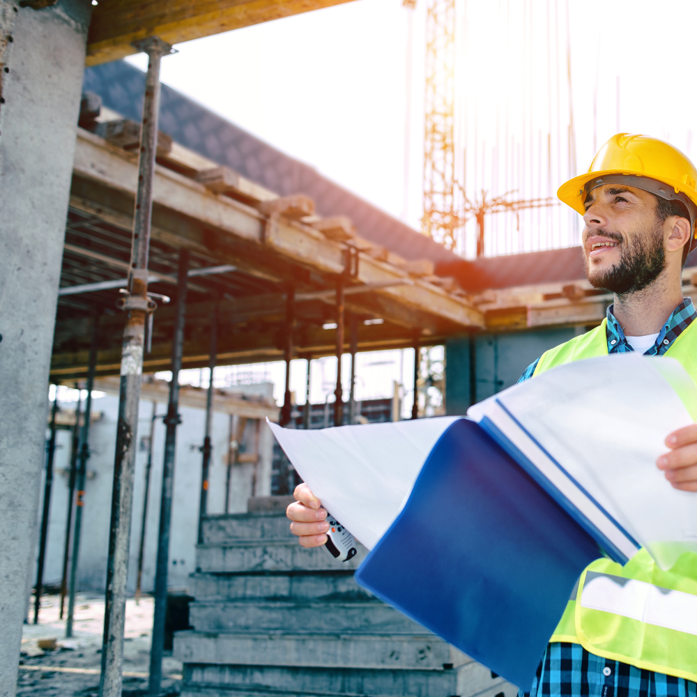 Bauleiter mit Plänen auf der Baustelle – Referenz aus dem Bauwesen
